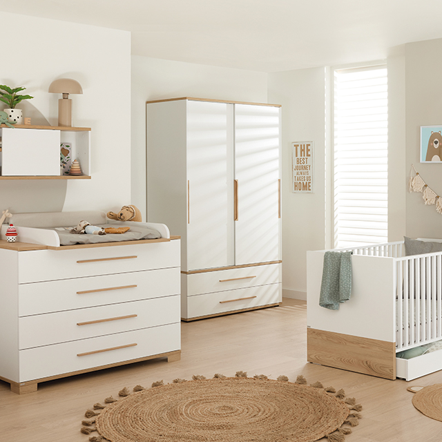 Bright, modern nursery with white furniture, wooden accents, and cozy decor.