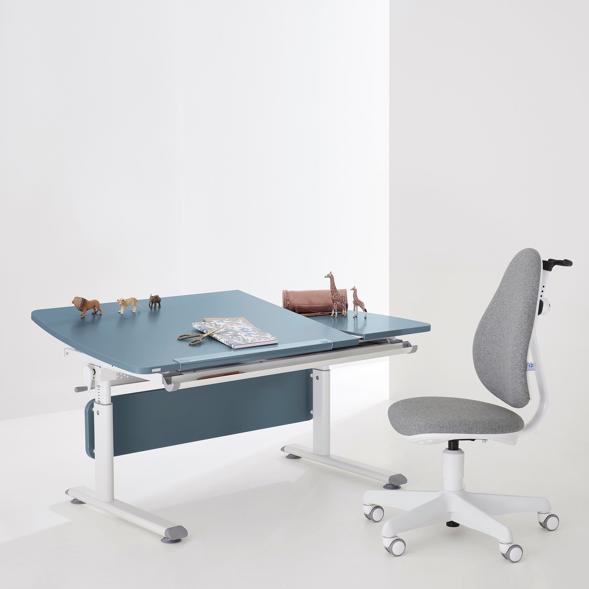 Blue adjustable desk with toy animals, books, and a gray office chair nearby.