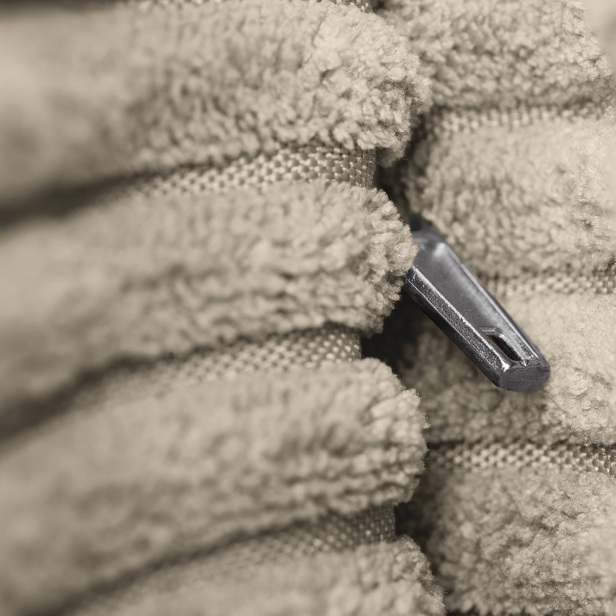 Nahaufnahme eines Reißverschlusses zwischen gefalteten, flauschigen beigen Handtüchern.