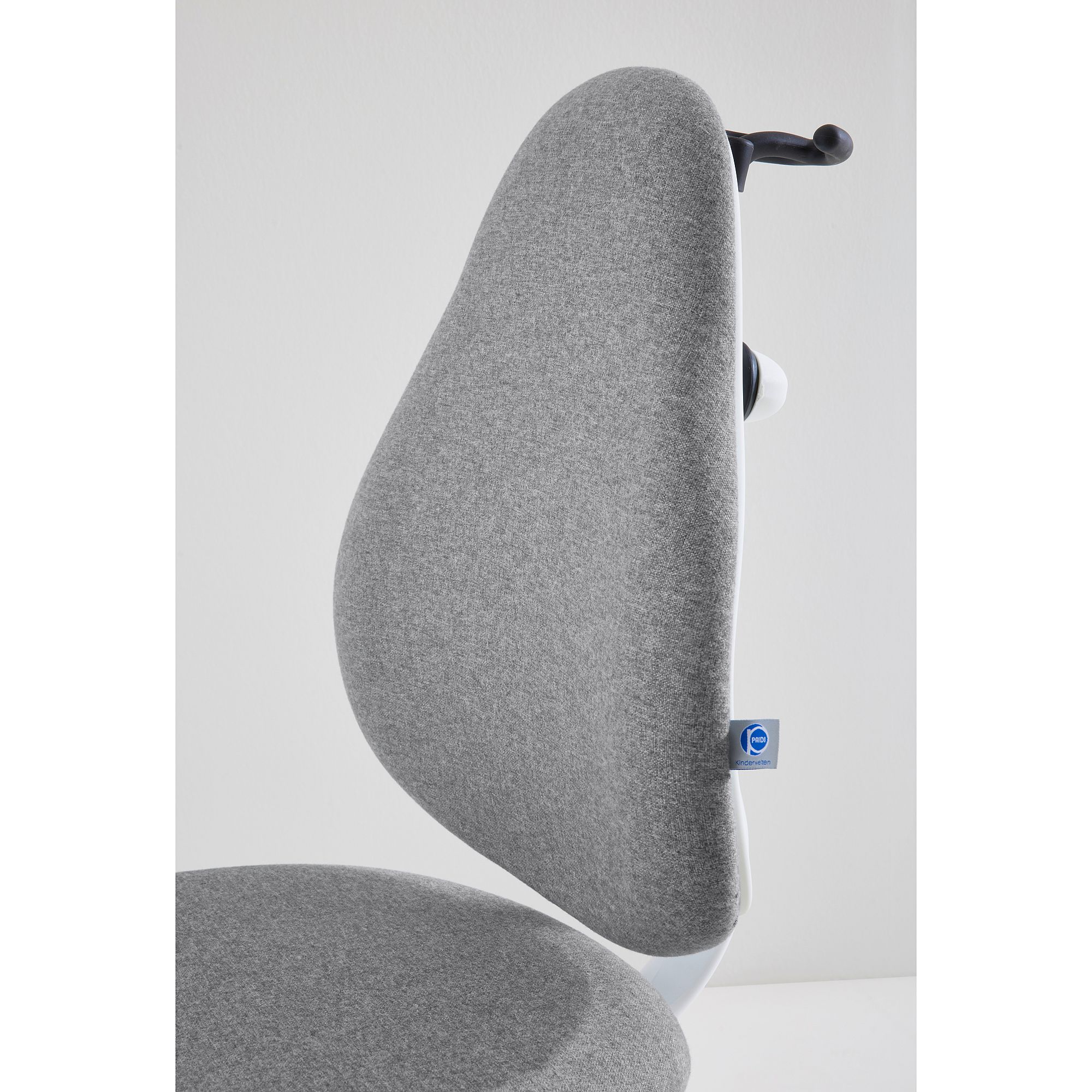 Gray ergonomic chair backrest with a fabric cover, side view against white wall.