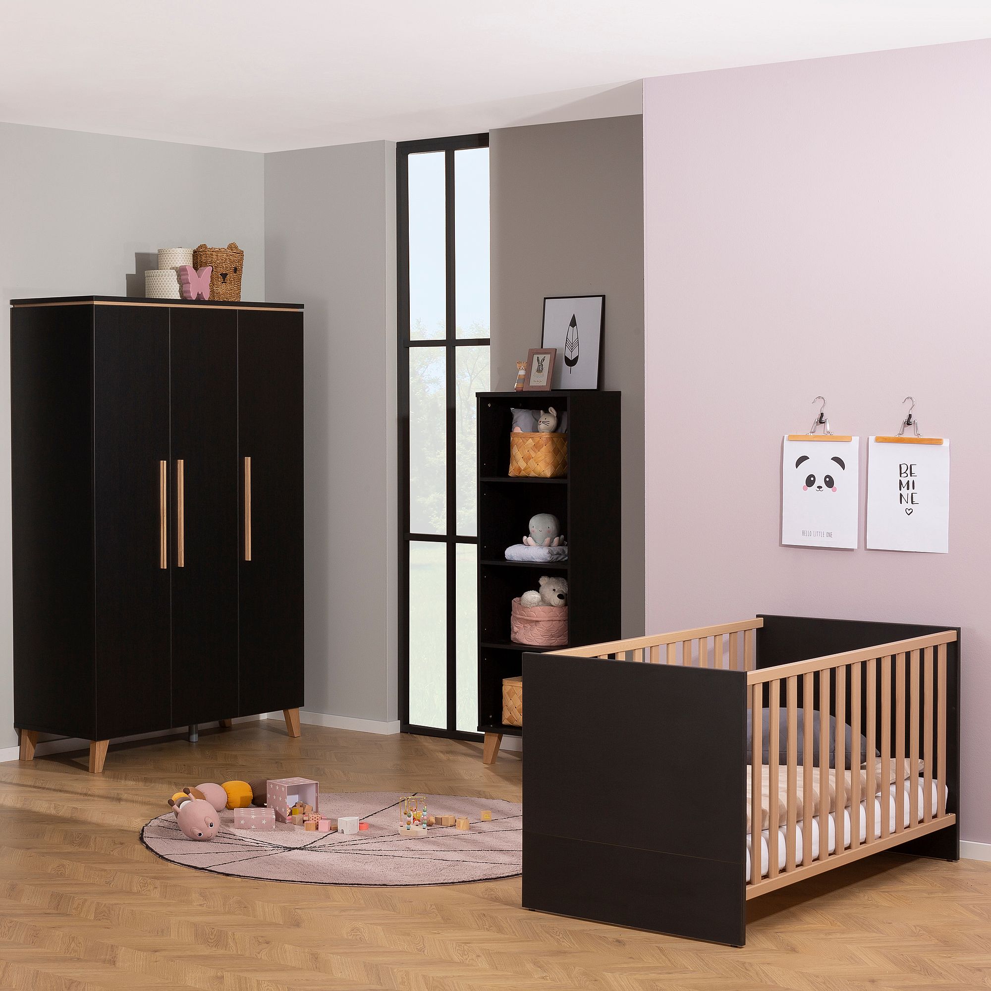 Modernes Kinderzimmer mit schwarzen Möbeln, Kinderbett, Kuscheltieren und pastellfarbenem Dekor.