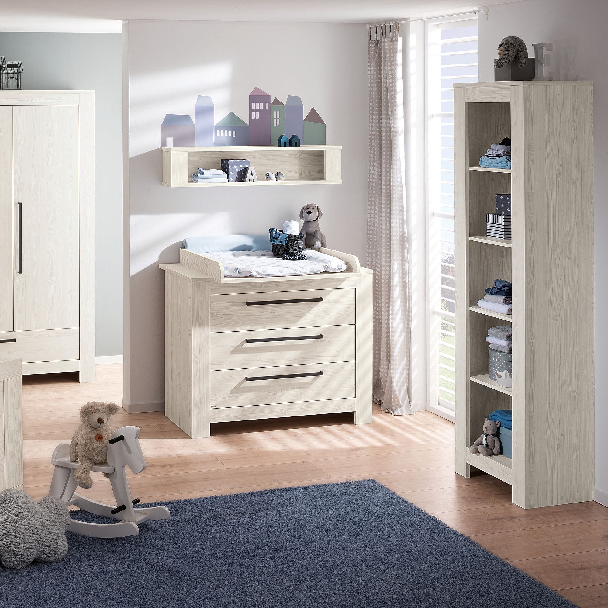 Modernes Kinderzimmer mit hellen Holzmöbeln, Spielzeug und mit Plüschtieren dekorierten Regalen.