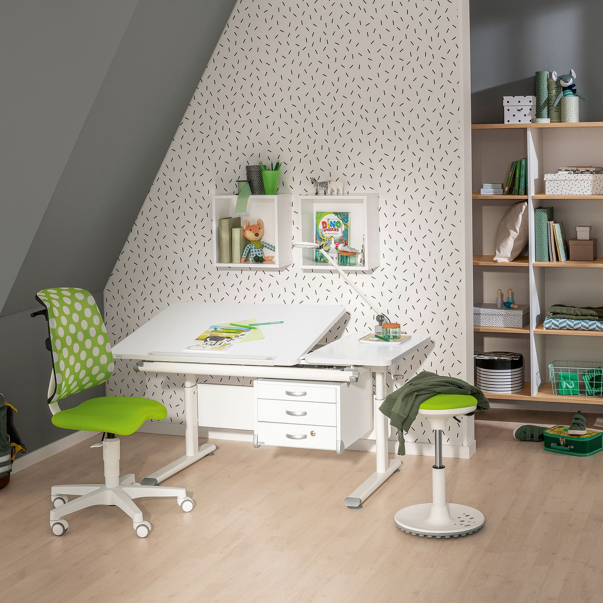 Moderner Lernbereich für Kinder mit grünem Stuhl, weißem Schreibtisch und Regalen mit Büchern.