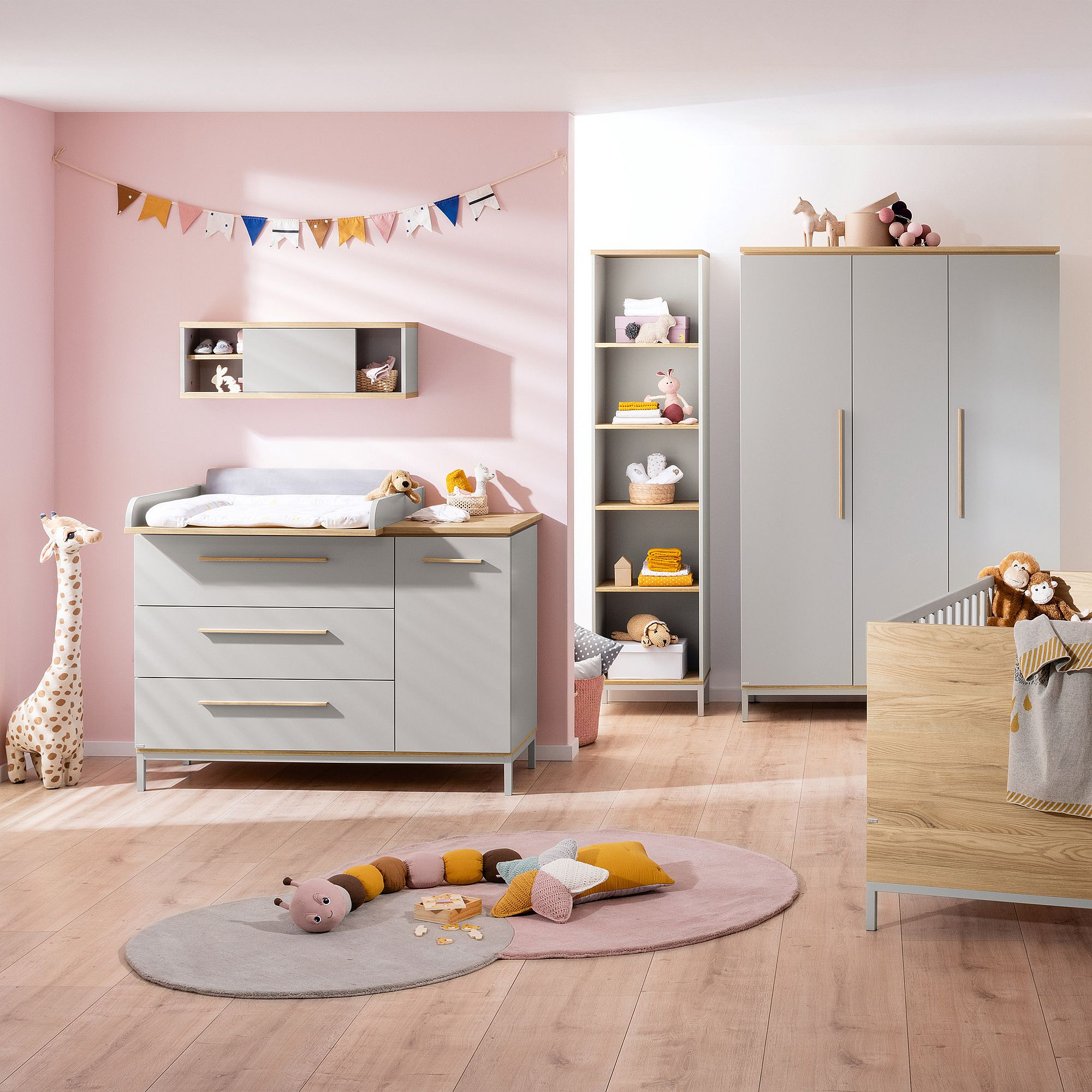 Modernes Kinderzimmer mit pastellfarbenem Dekor, Spielzeug, einem Kinderbett, einer Kommode und einem Kleiderschrank.