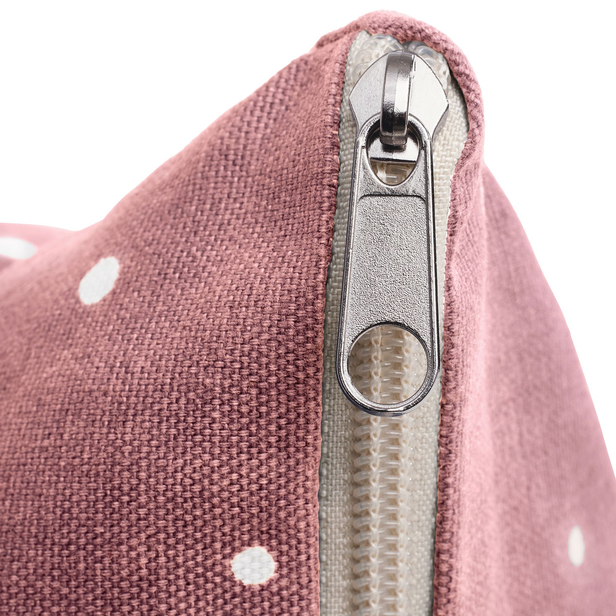 Nahaufnahme eines Reißverschlusses an einem rosa, gepunkteten Stoffbeutel.