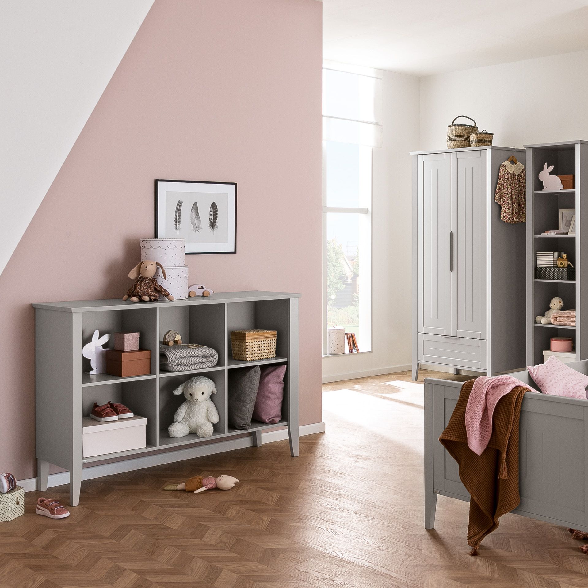 Children’s bedroom with pink and gray decor, toys, shelves, and a bed.