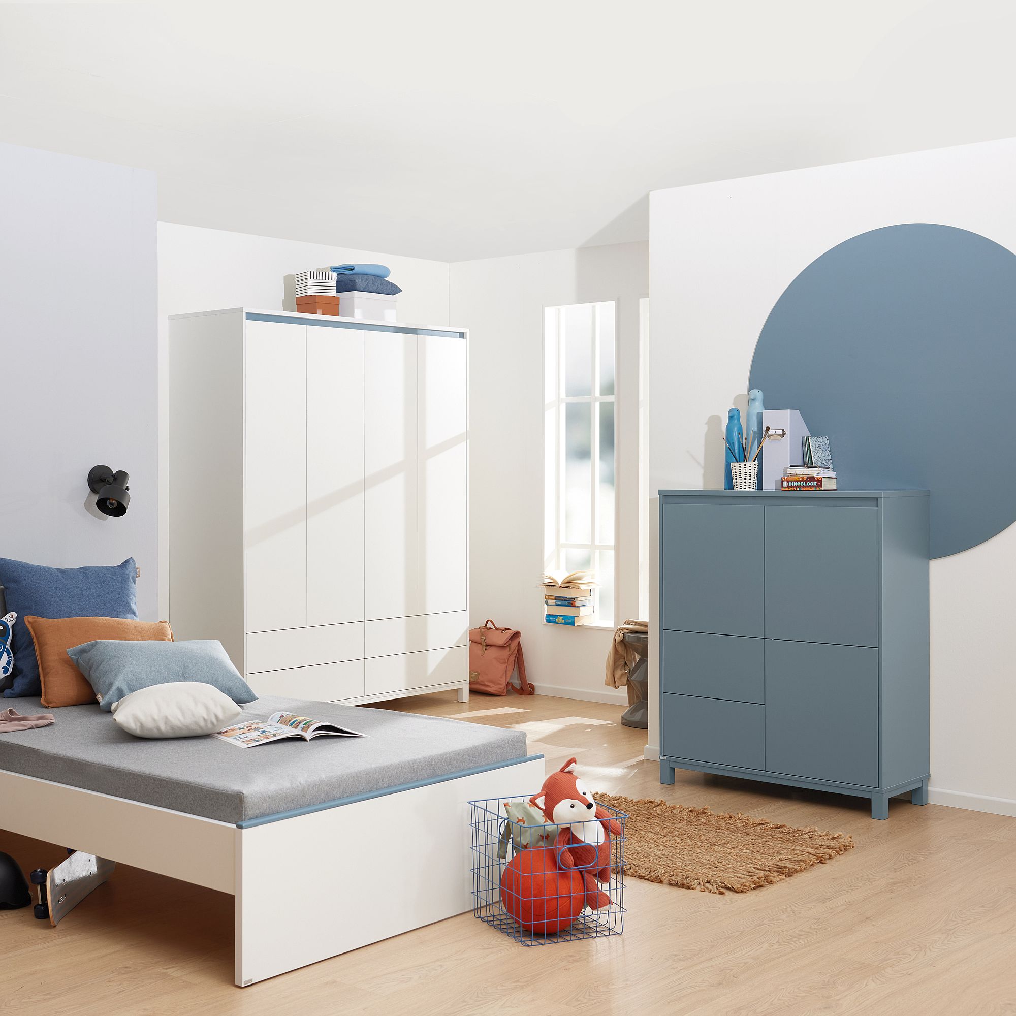 Modernes, minimalistisches Kinderzimmer mit weißen Möbeln und blauen Akzenten.