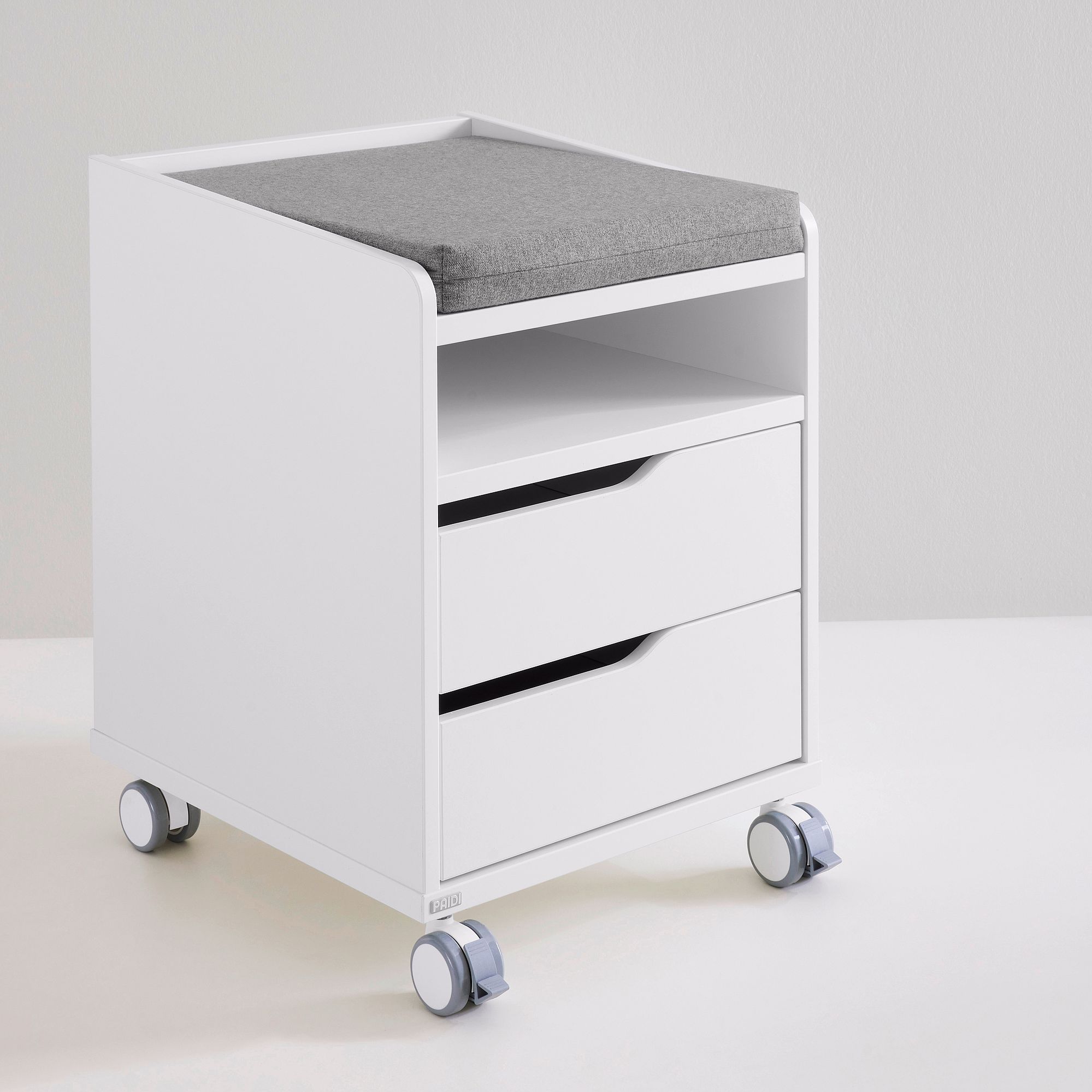 Rollcontainer  mit 2 Schubladen in Kreideweiß Weißer Rollcontainer mit zwei Schubladen, offenem Regal und grauer gepolsterter Platte.