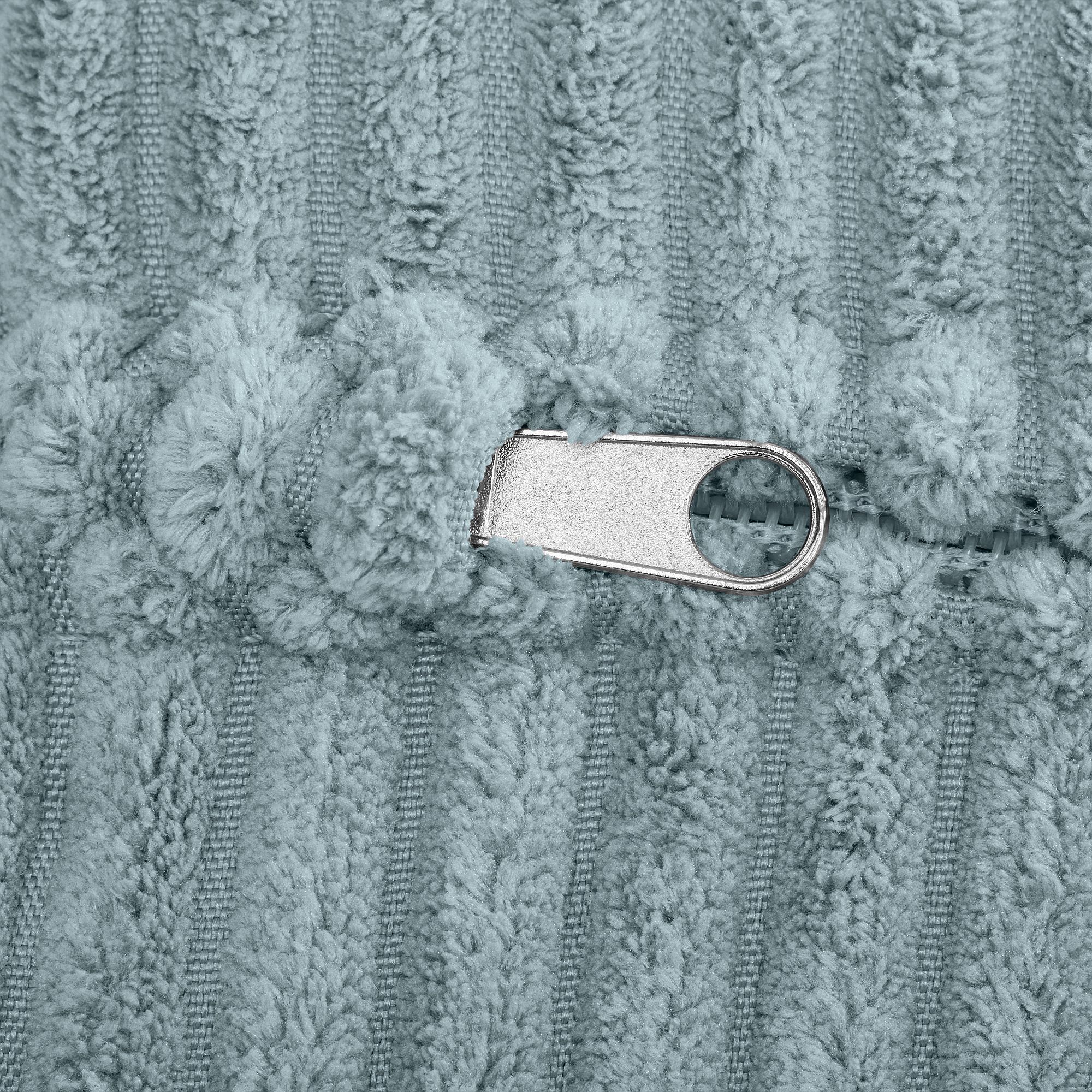 Nahaufnahme eines silbernen Reißverschlusses auf hellblauem, strukturiertem Stoff.