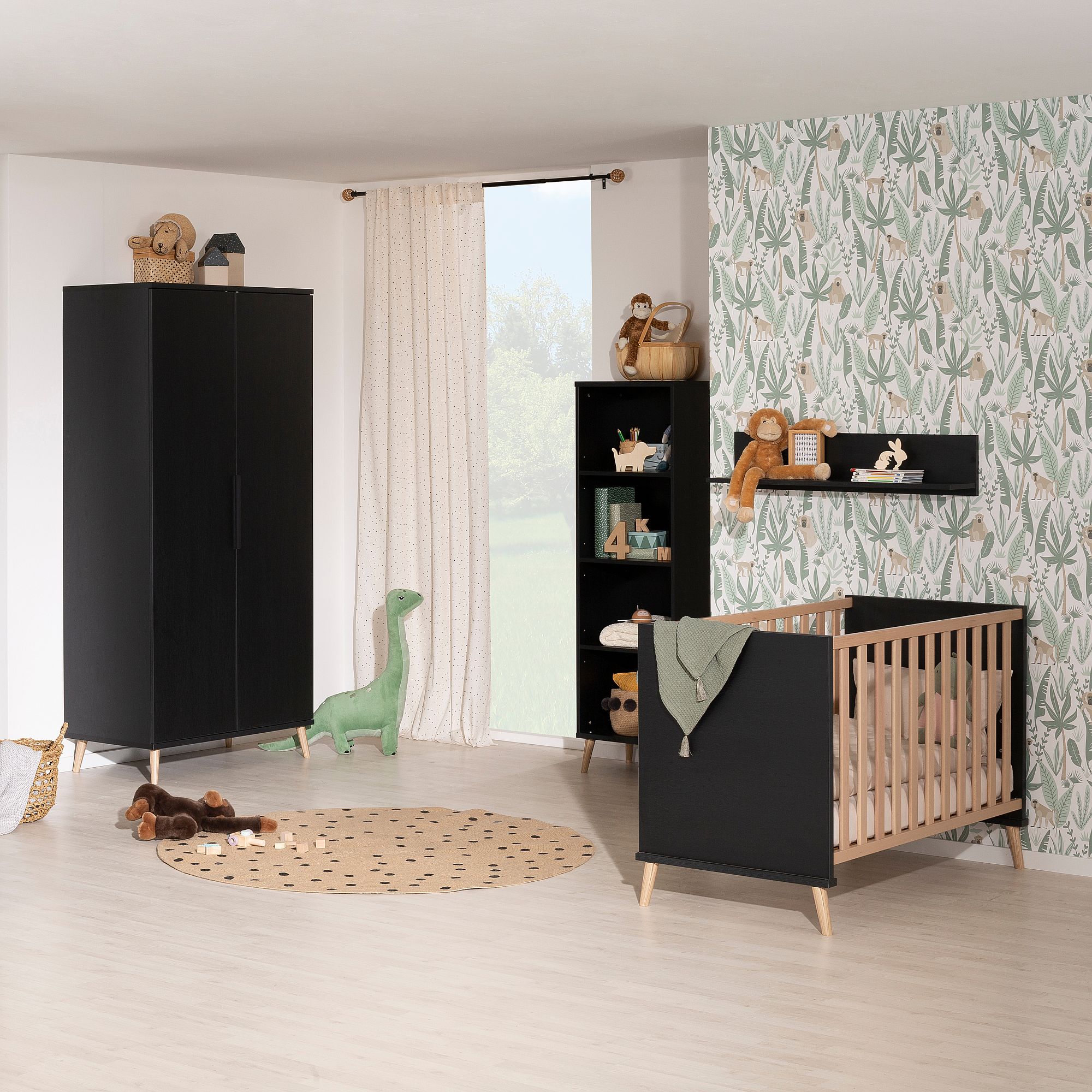 Modernes Kinderzimmer mit schwarzen Möbeln, Kinderbett, Spielzeug und Blättertapete.